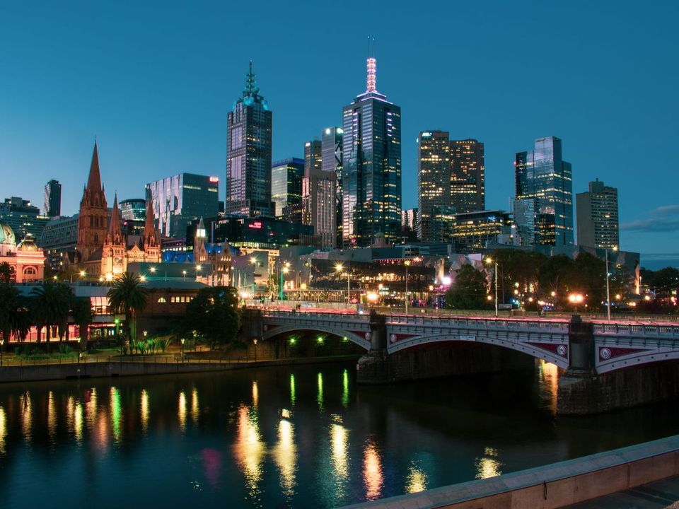 Melbourne's city skyline lit up at dusk across the Yarra River