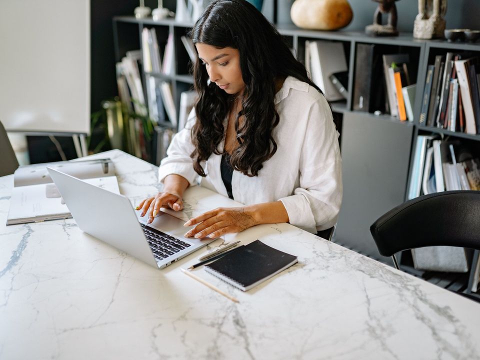 A business student working on a laptop in an office