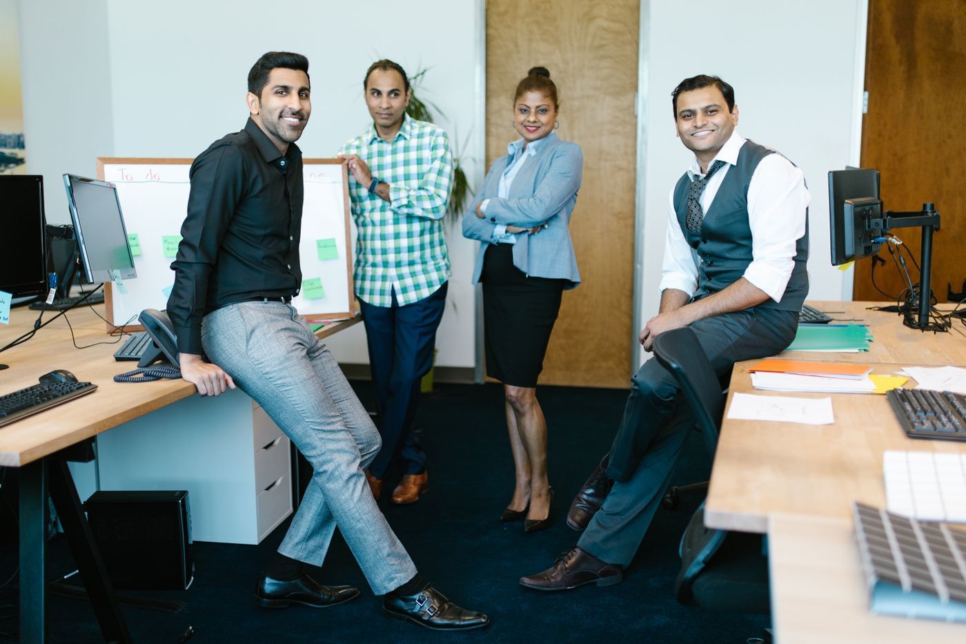 Four colleagues standing together in a bright office