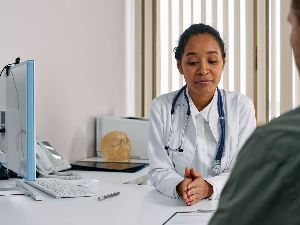 A doctor talking with a patient at a clinic desk