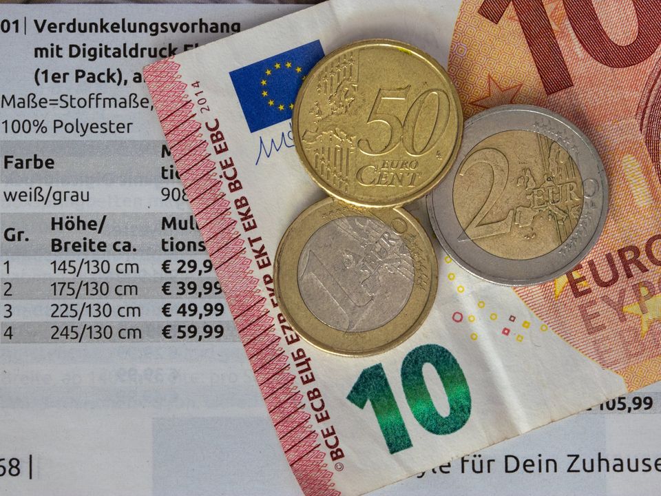 Euro coins and notes on a printed price list