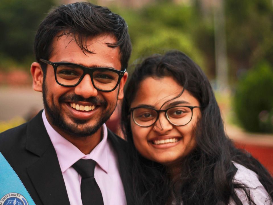 Two graduates smiling together on graduation day