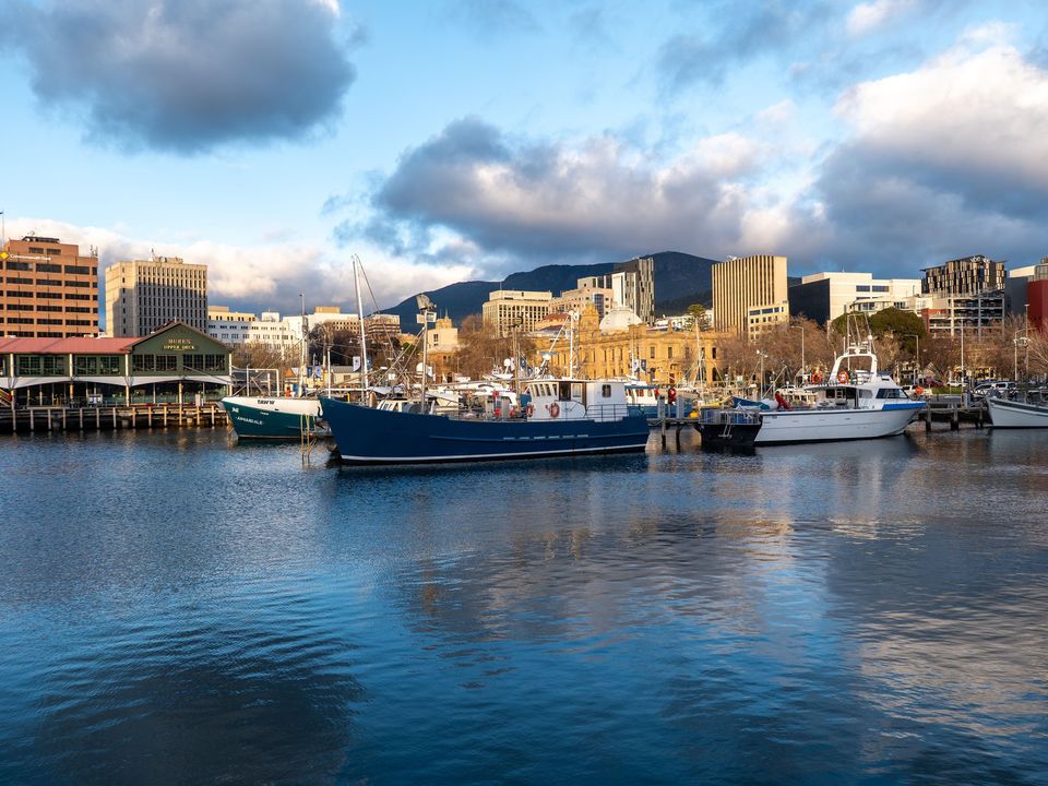 Hobart's waterfront with fishing boats under a cloudy sky