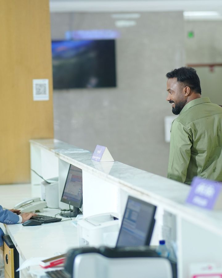 A hotel front-desk trainee helping a guest at reception
