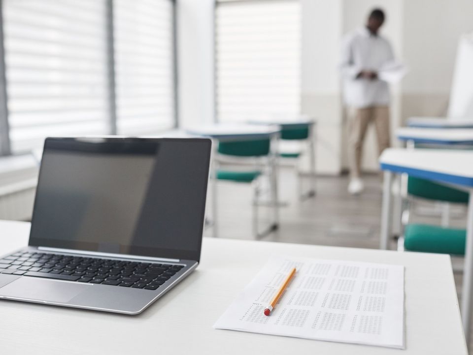 A laptop open on a plain desk, ready for a computer-based test