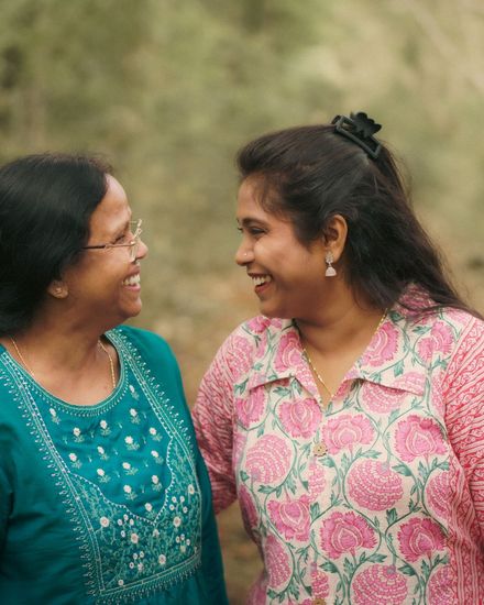 A mother and daughter laughing together outdoors