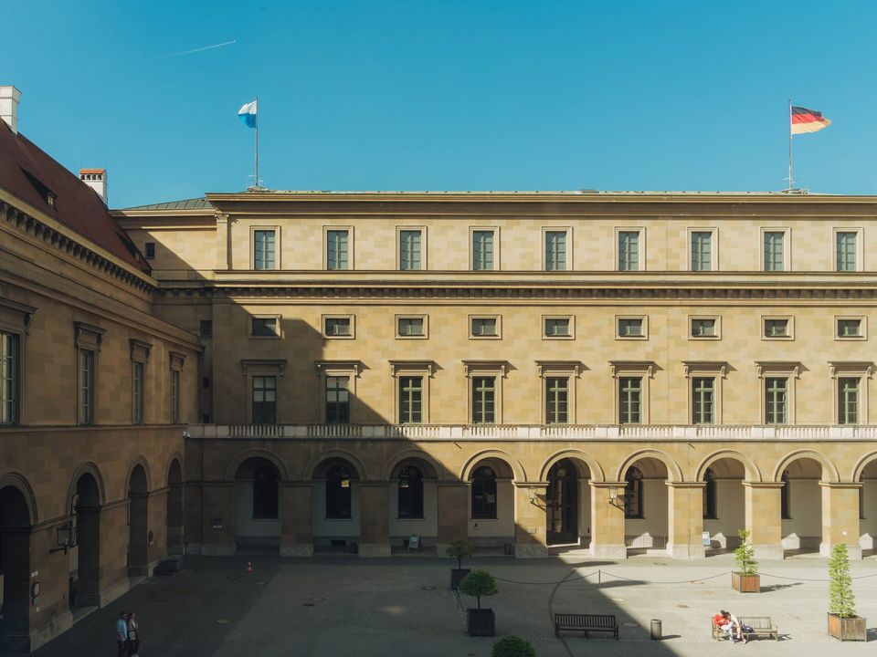 A university courtyard in Munich with the German flag on the roof
