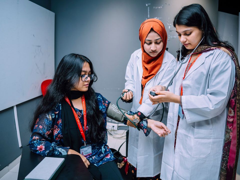 Nursing students practising patient checks with a tutor