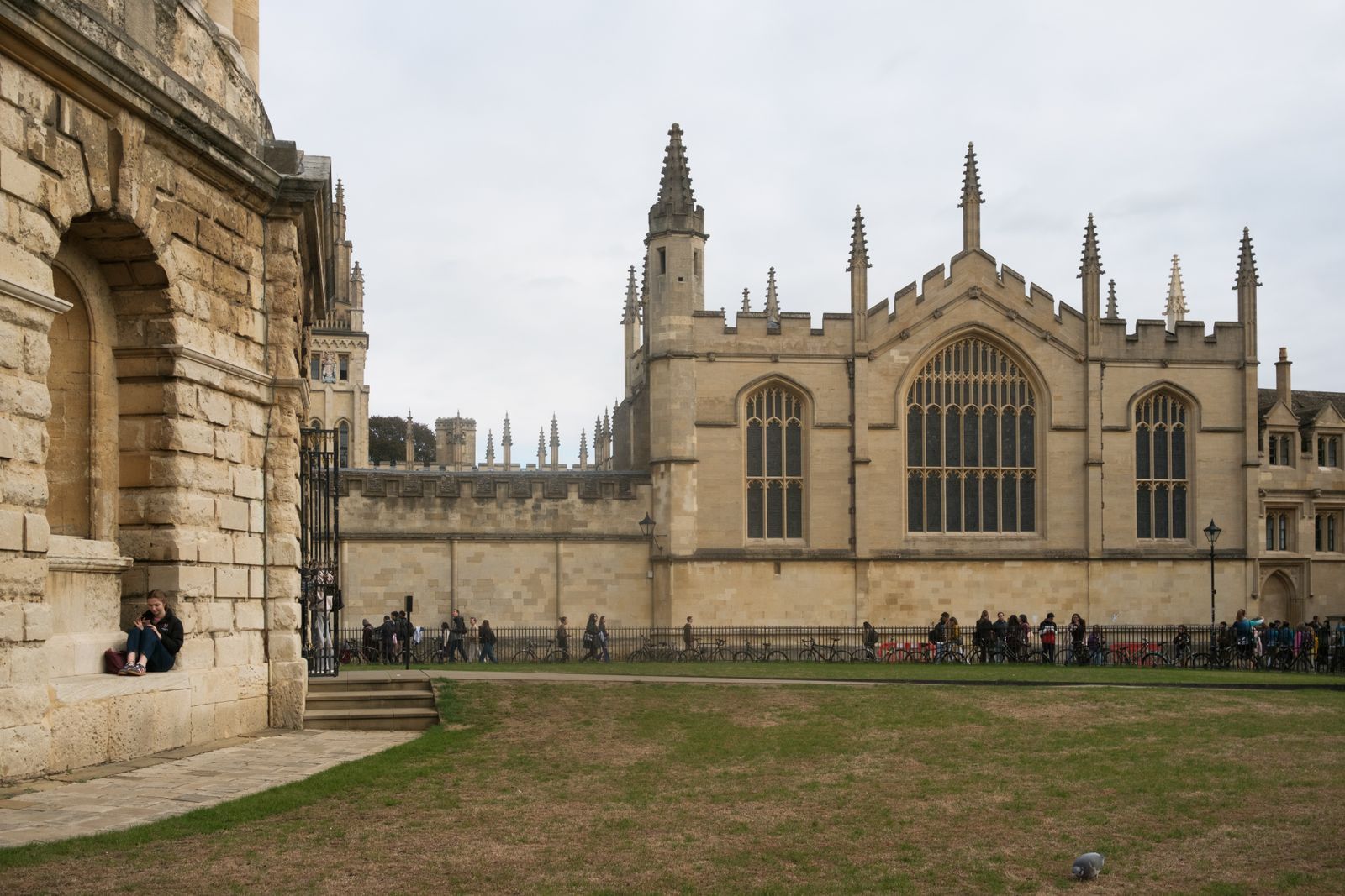 Students relaxing outside a historic college building in Oxford, England