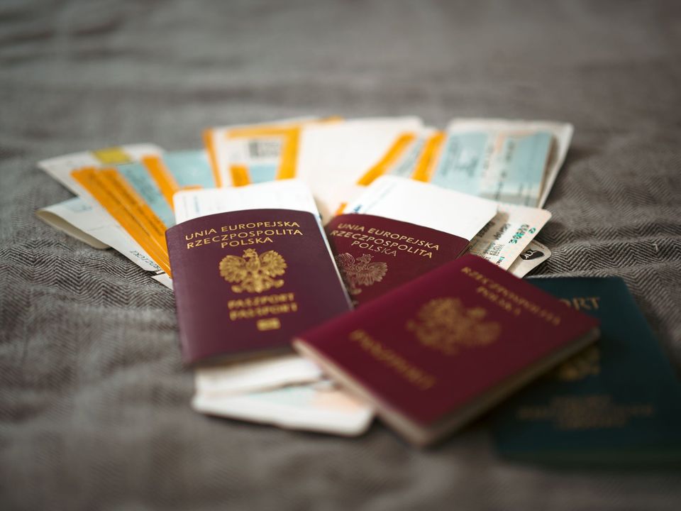 Passports and travel documents laid out on a bed before a trip