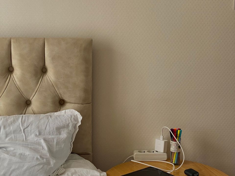 A simple student room with a bed, a desk and a window