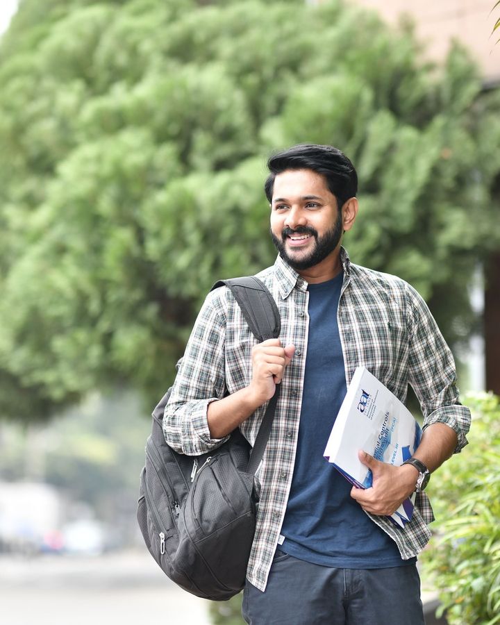 A student with a backpack and books walking outdoors