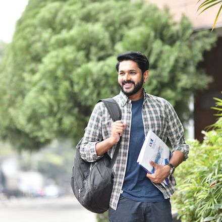 A student with a backpack and books walking outdoors