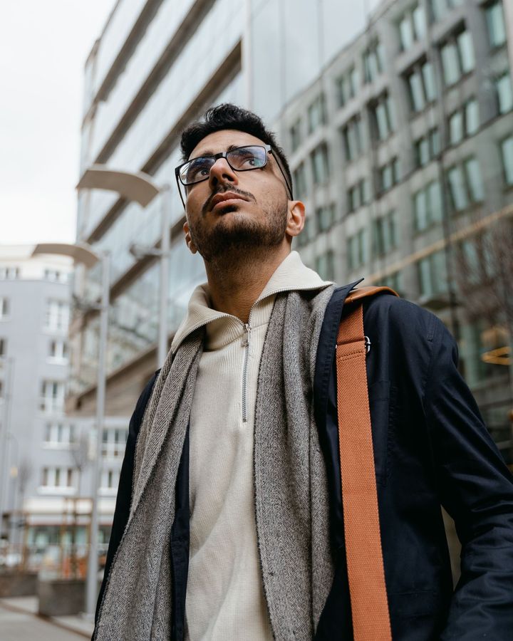 A student with a shoulder bag among modern city buildings