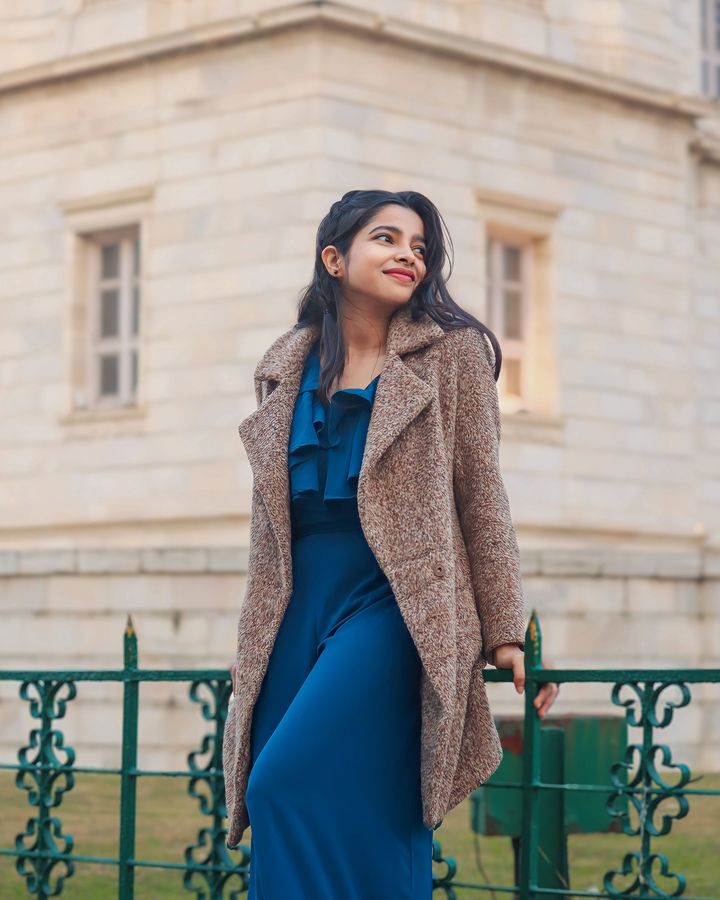 A student in a winter coat outside an old European building