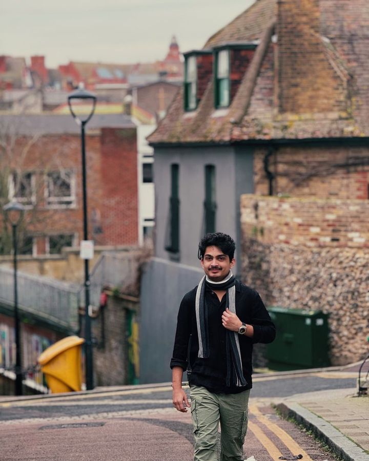 A student walking down a cobbled street in an old German town