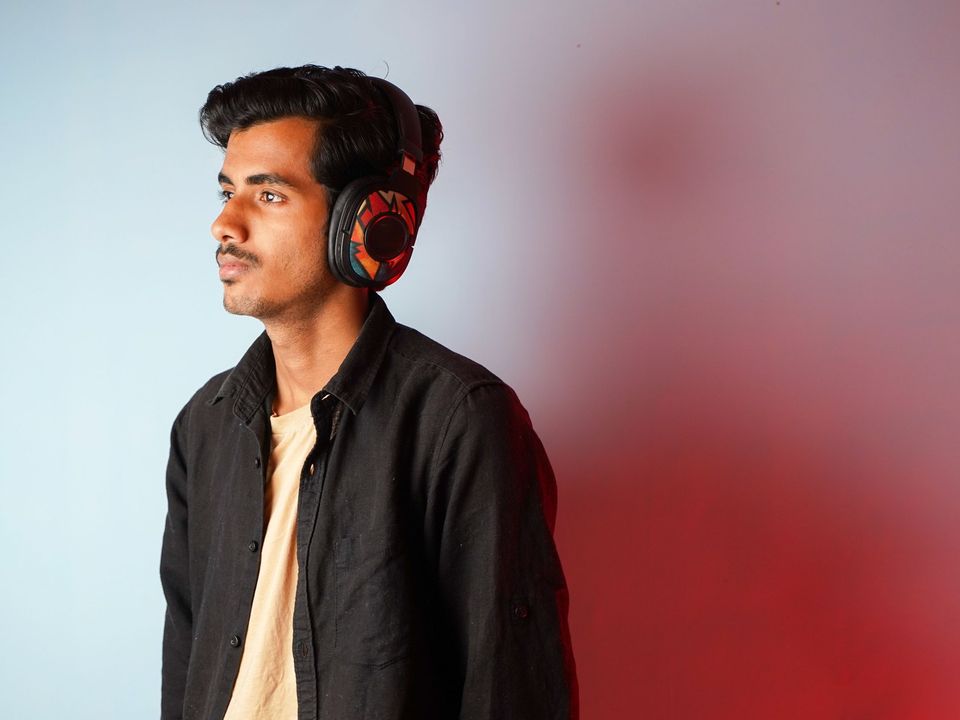 A student wearing headphones and listening closely at a desk