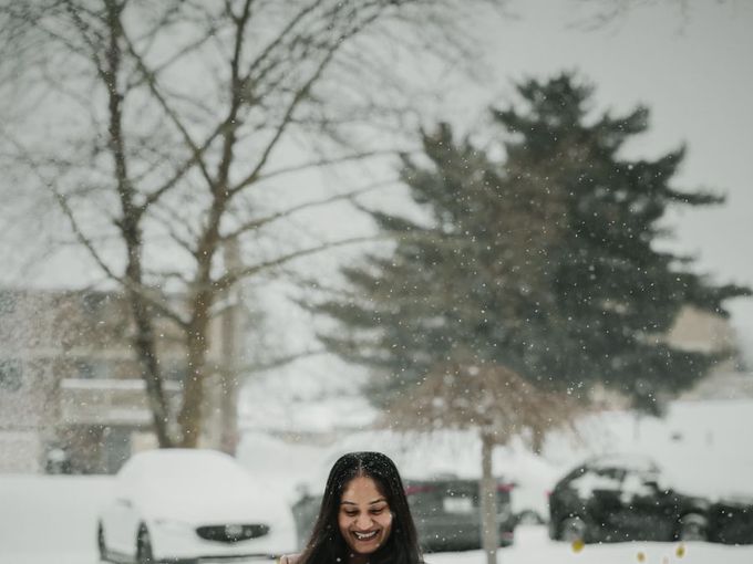 A student in a long winter coat standing in fresh snow