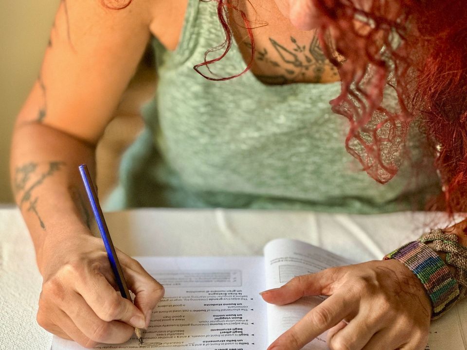 A student writing exercises in a language workbook