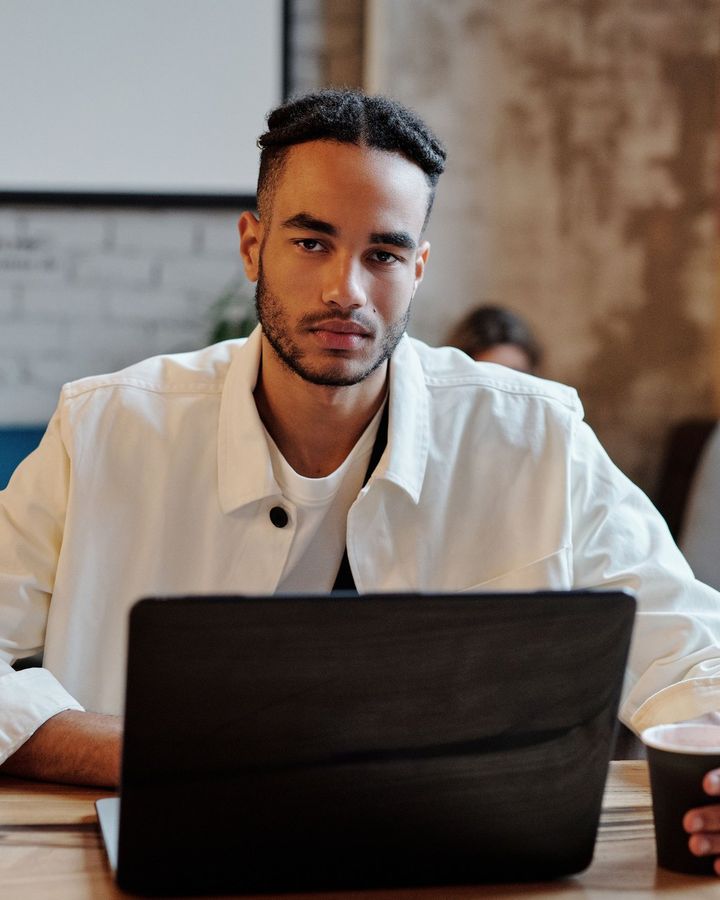 A student focused on his laptop in a cafe