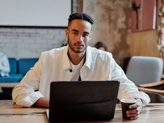 A student focused on his laptop in a cafe