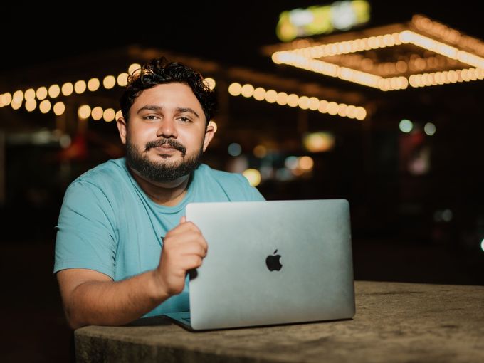 A student working on his laptop in a cafe with warm lights