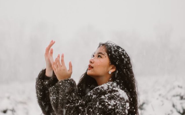 A student looking up at falling snow