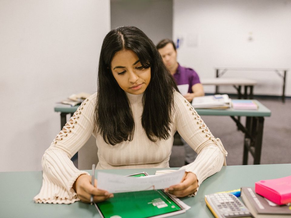 A student reading a printed results sheet