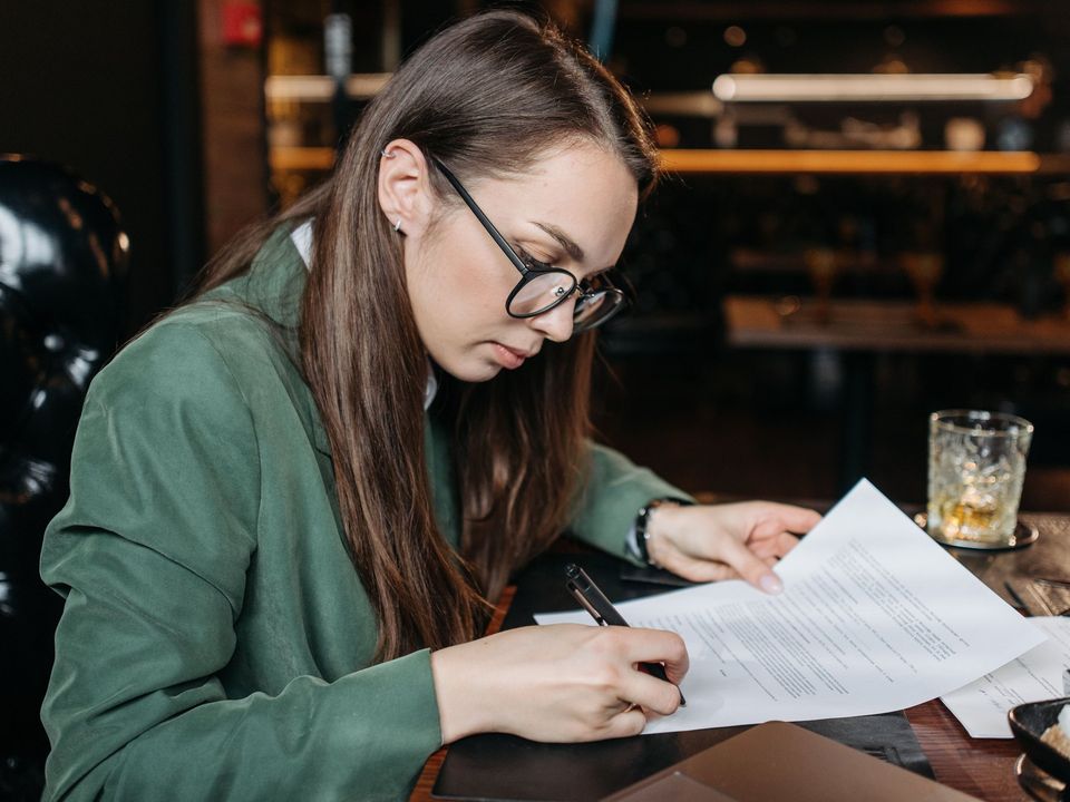 A student signing a document at her desk