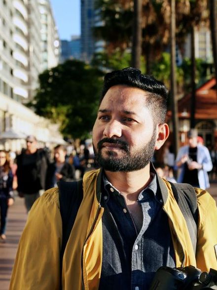 A man enjoys a sunny day on the bustling streets of Sydney, NSW, Australia.