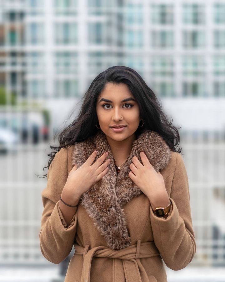 A smiling student in a winter coat and scarf