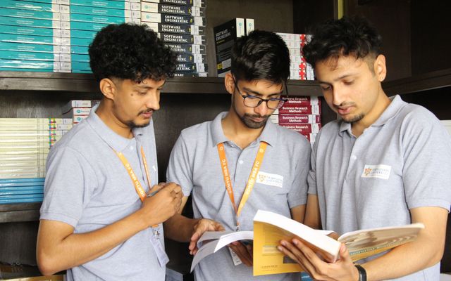 Three students reading notes together