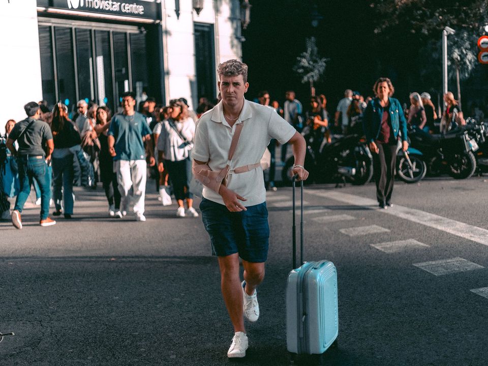 A traveller with a suitcase walking down a city street